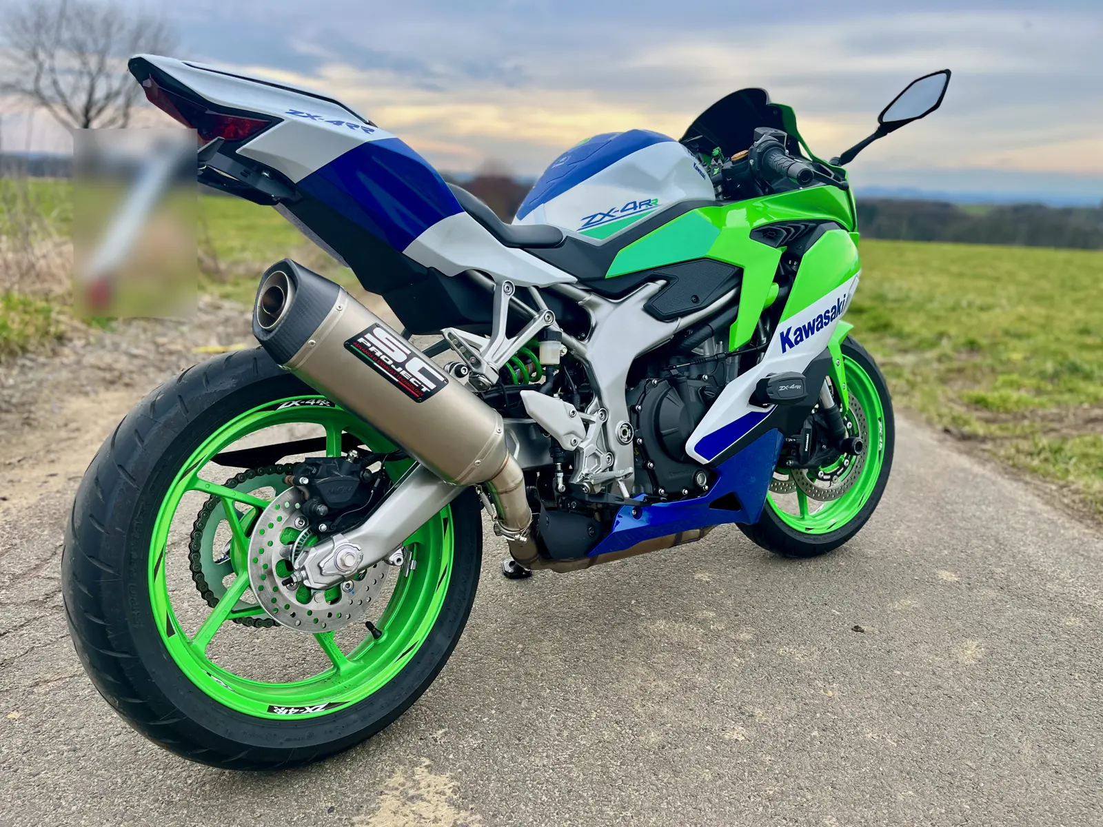 Kawasaki ZX-4RR in Grün, Weiß und Blau von schräg hinten auf einem Feldweg